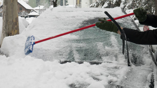 ręce mężczyzny oczyszczają śnieg z przedniej szyby samochodu. - snow car window ice scraper zdjęcia i obrazy z banku zdjęć