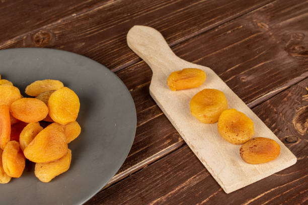 istock Dried orange apricot on brown wood 1185920312