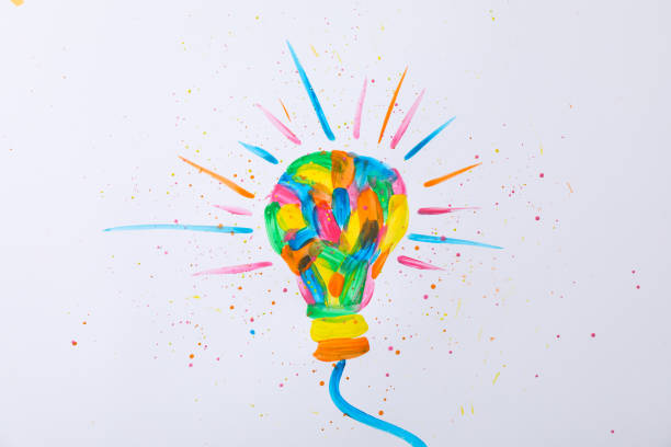 istock Multicolored light bulb and paint splatters on white background, space for text 1185920418