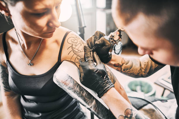 istock Artist Tattooing woman's shoulder 1185921842