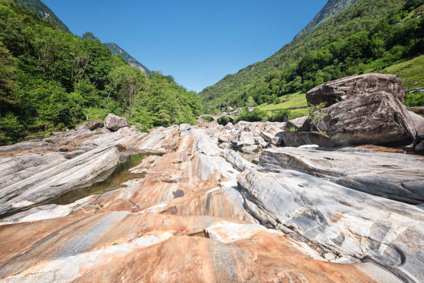 lavado de rocas en el lecho del río verzasca con puente ponte des salti - riverbed switzerland valley stone fotografías e imágenes de stock