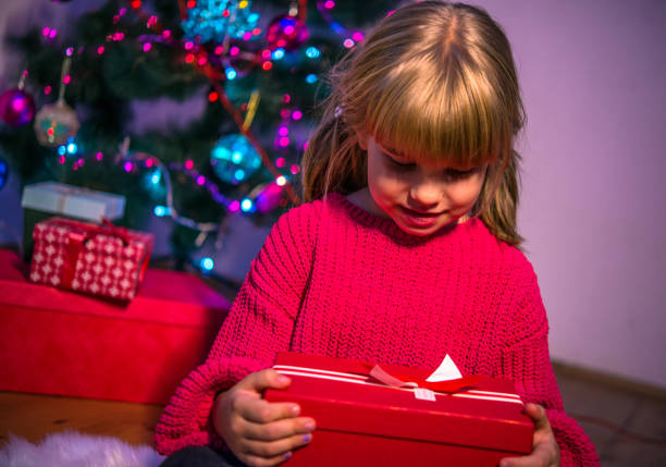 istock little girl holds the gift 1185925253