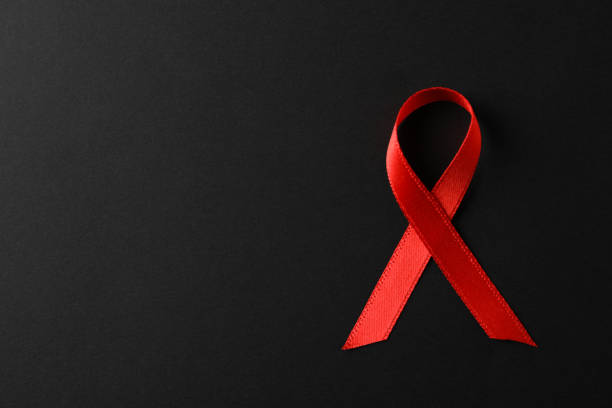 istock AIDS awareness red ribbon on black background, space for text 1185928375