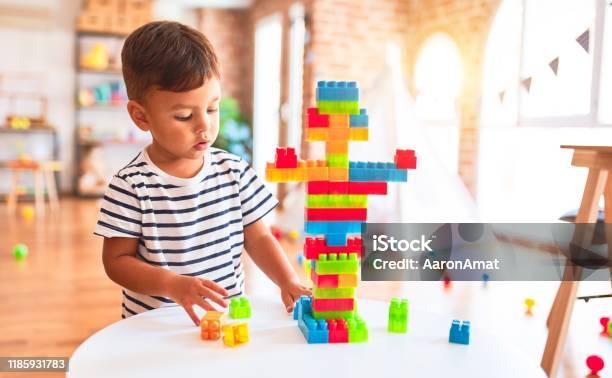 Foto de Menino De Criança Bonito Que Joga Com Blocos De Construção No Jardim De Infância e mais fotos de stock de Criança