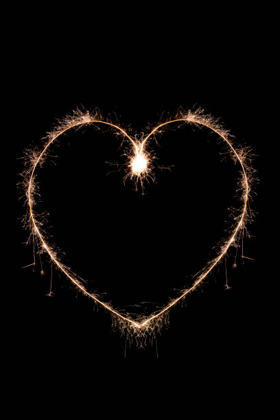 istock Golden sparklers glowing heart on black 1185931983