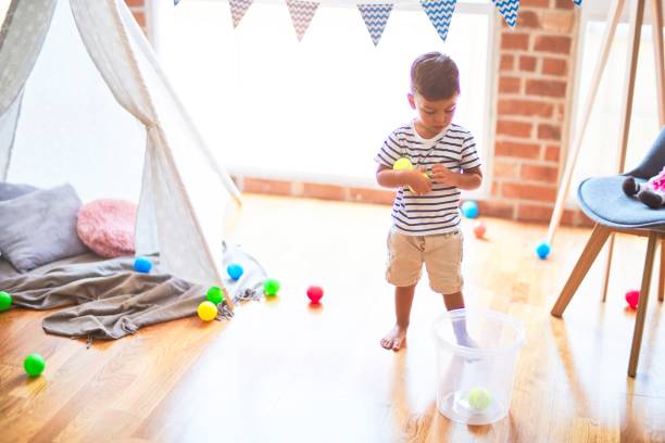istock Beautiful toddler boy playing with colored small balls at kindergarten 1185932015