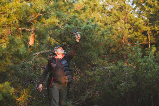 człowiek szuka sygnału dla telefonu komórkowego w lesie - discovery forest lost confusion zdjęcia i obrazy z banku zdjęć