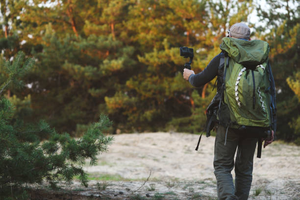 istock Man holds stabilizer with smartphone in forest. 1185932138