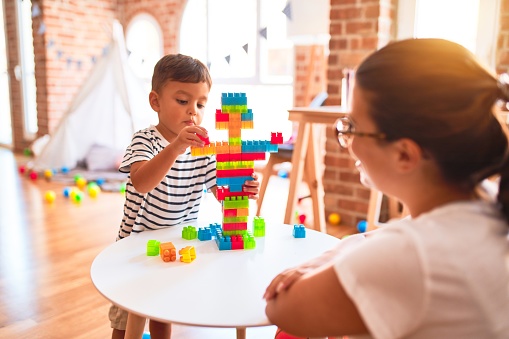 A little boy spends time with his mother and plays with blocks.