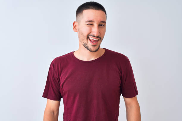 istock Young handsome man standing over isolated background winking looking at the camera with sexy expression, cheerful and happy face. 1185933288