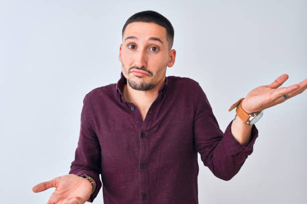 istock Young handsome business man standing over isolated background clueless and confused expression with arms and hands raised. Doubt concept. 1185934003