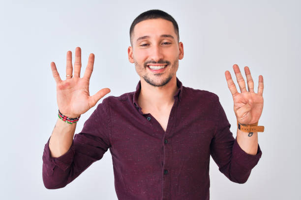 istock Young handsome business man standing over isolated background showing and pointing up with fingers number nine while smiling confident and happy. 1185934113