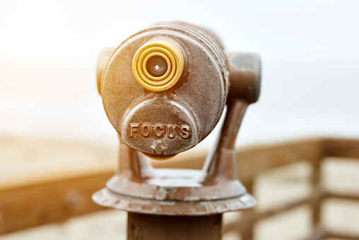 Telescope on a Beach Pier with the Words Focus Engraved
