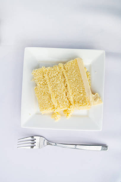 istock Flat top closeup of table setting of restaurant or wedding reception white table tablecloth one plate with vanilla cream cake slice and fork 1185936103