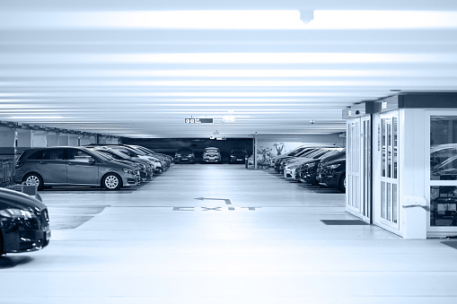 Parking cars without people. Many cars in parking garage interior, industrial building. Underground parking with cars.Toning
