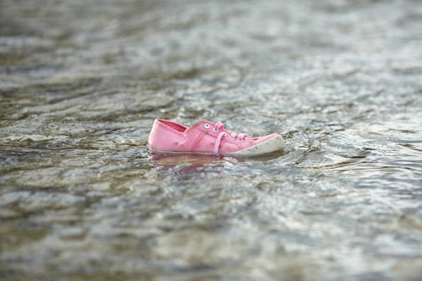 Children's shoes by the sea. Homeless child. Refugee problem. Concept of finding a better life.