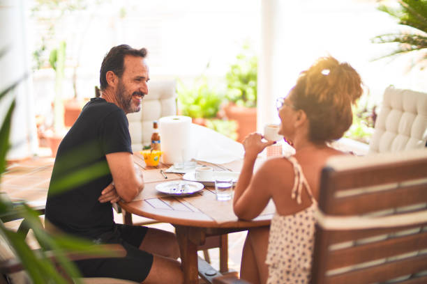 istock Middle age beautiful couple sitting on terrace drinking cup of coffe 1185938933