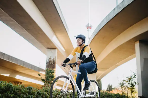 A beautiful young African American woman enjoys a sunny autumn day in downtown Tacoma, Washington, using her bike for transportation to go to class or work.