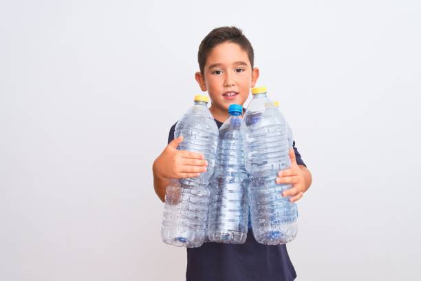 istock Beautiful kid boy recycling plastic bottles standing over isolated white background with a happy face standing and smiling with a confident smile showing teeth 1185940906