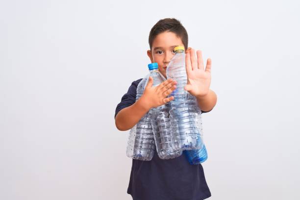 istock Beautiful kid boy recycling plastic bottles standing over isolated white background with open hand doing stop sign with serious and confident expression, defense gesture 1185941000