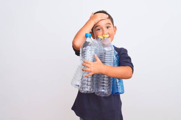 istock Beautiful kid boy recycling plastic bottles standing over isolated white background stressed with hand on head, shocked with shame and surprise face, angry and frustrated. Fear and upset for mistake. 1185941014