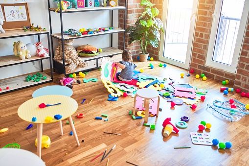 Hermoso niño sentado en el suelo jugando con bloques de construcción juguete en el jardín de infantes photo