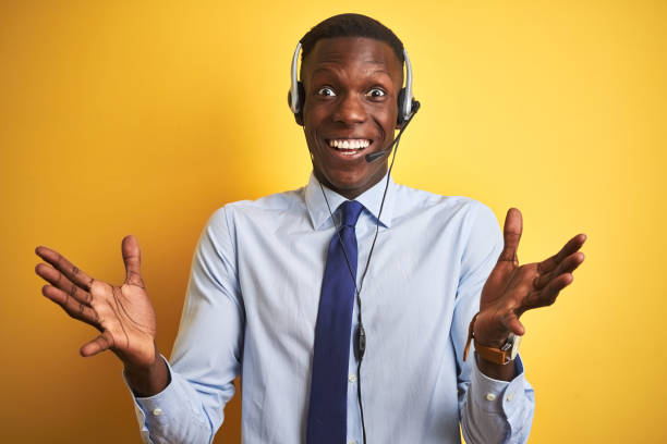 istock African american operator man working using headset over isolated yellow background celebrating crazy and amazed for success with arms raised and open eyes screaming excited. Winner concept 1185943571