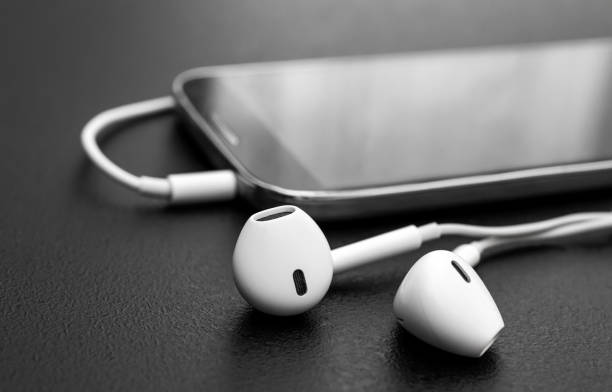 istock Headphones with smartphone on black. Close up. 1185947272