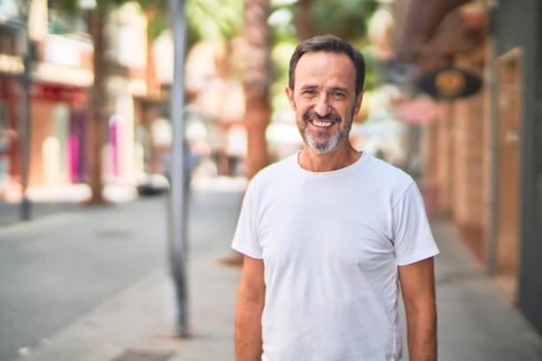 Middle age handsome man standing on the street smiling