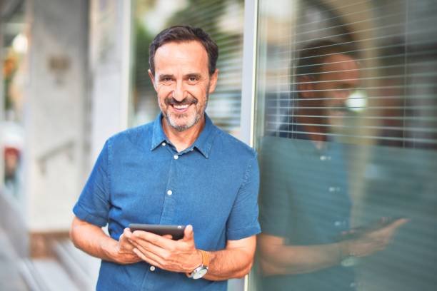 istock Middle age handsome businessman using tablet smiling leaning on the wall 1185950052