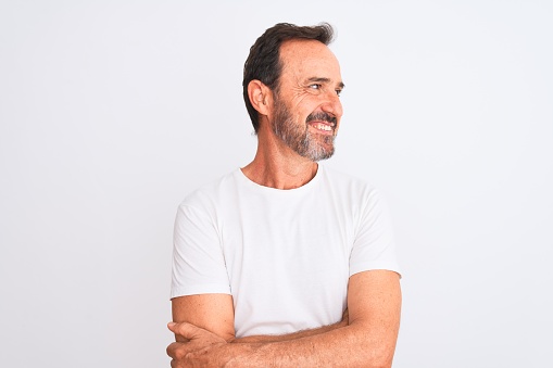 Middle age handsome man wearing casual t-shirt standing over isolated white background smiling looking to the side and staring away thinking.