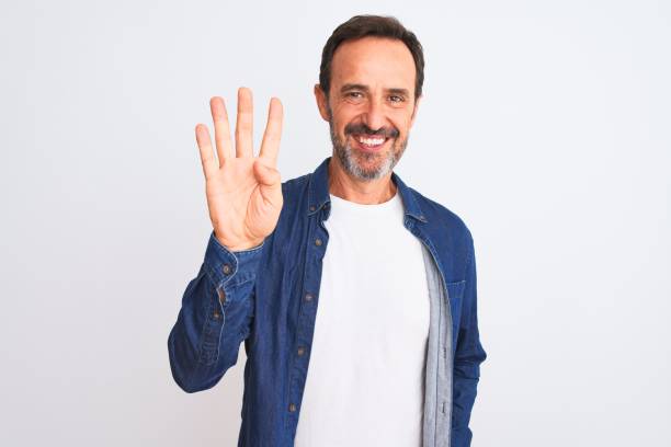istock Middle age handsome man wearing blue denim shirt standing over isolated white background showing and pointing up with fingers number four while smiling confident and happy. 1185950320