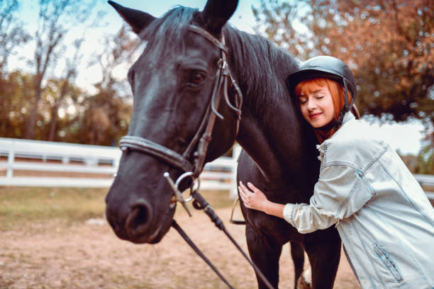 istock Female Hugging A Beautiful Black Horse 1185950675