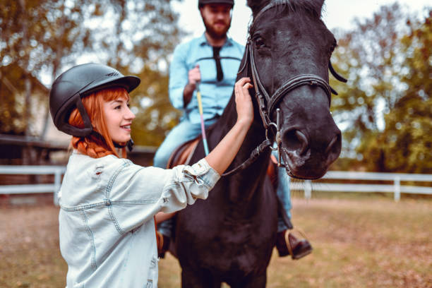 istock Female Instructor Leading Handsome Male On Horse 1185951774