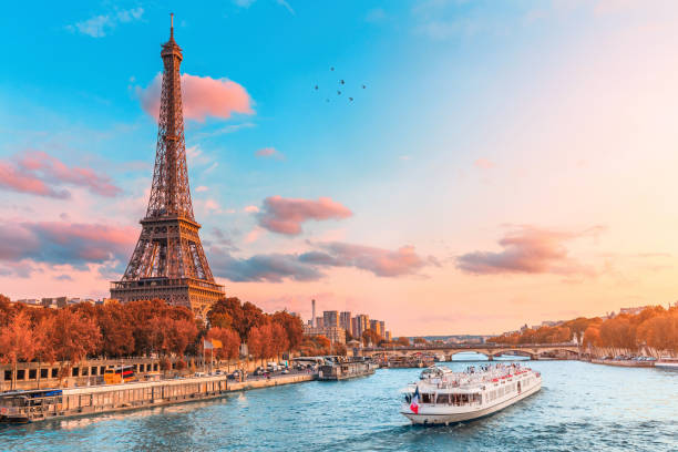 The main attraction of Paris and all of Europe is the Eiffel tower in the rays of the setting sun on the bank of Seine river with cruise tourist ships stock photo