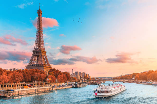 a principal atração de paris e toda a europa é a torre eiffel nos raios do sol poente na margem do rio sena com navios turísticos de cruzeiro - torre-eiffel - fotografias e filmes do acervo