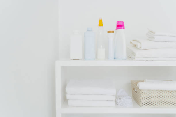 istock Stack of clean white towels with detergents on console isolated over white background. Fresh laundry and liquid washing in bathroom 1185955427