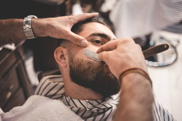 barber se afian la barba del cliente - cortar fotos fotografías e imágenes de stock