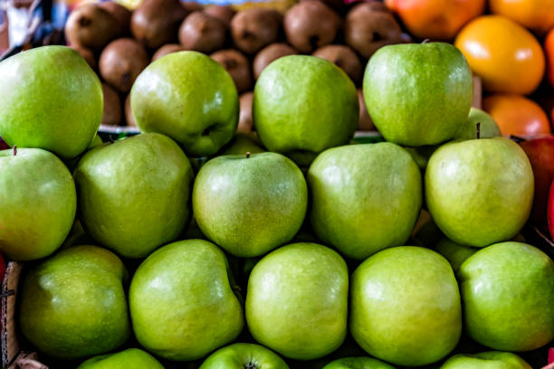 Close-up View at the Fresh and Delicious Green Apples at the Farmers Market. An Apple is a Sweet, Edible Fruit Produced by an Apple Tree (Malus Pumila).