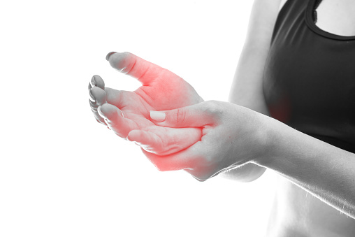 Woman holding her hand, filling pain isolated on white