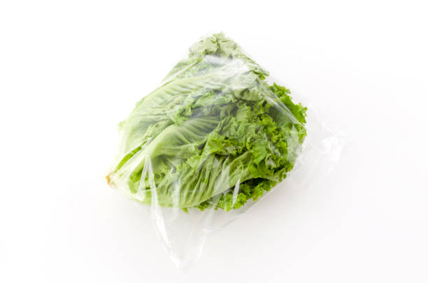 istock fresh green leaves lettuce in plastic bag on white background 1185963278