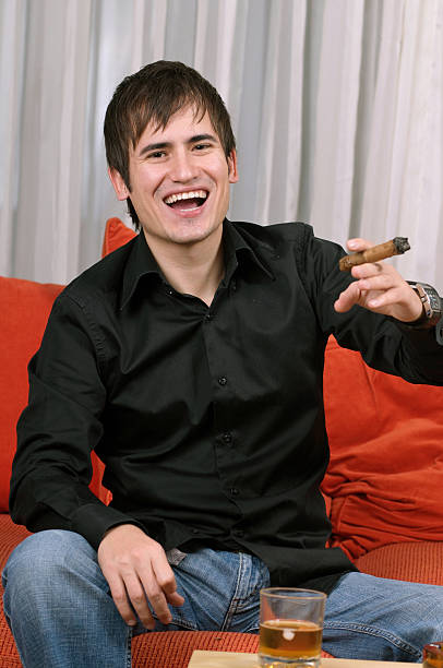 Man Enjoying Himself with Scotch and a Cigar stock photo