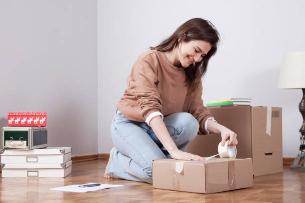 istock woman moving into new home with boxes 1185964294