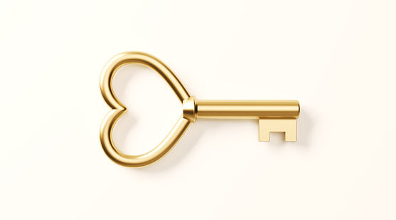 Gold heart shaped key on white background. Horizontal composition with clipping path and copy space.