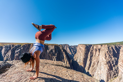 A beautiful woman doing handstands, and looking over The Black Canyon of the Gunnison.
