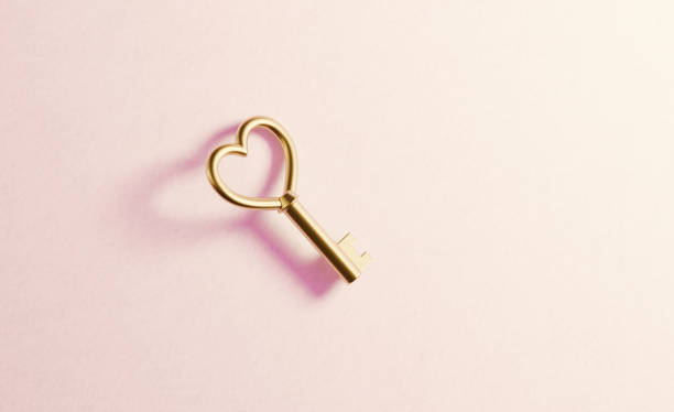 istock Gold Heart Shaped Key  on Red Background 1185966867