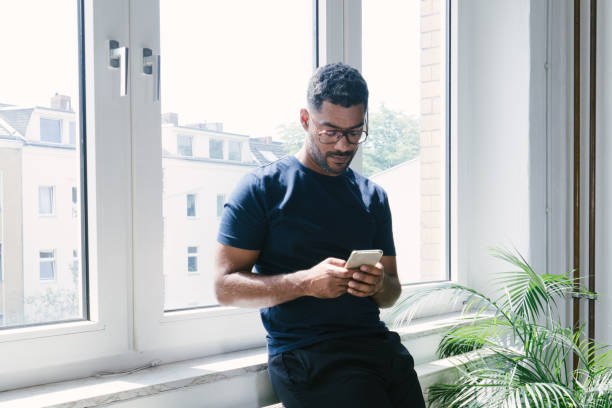 Portrait of a young man on the phone indoors Portrait of a young man on the phone indoors hipster person stock pictures, royalty-free photos & images