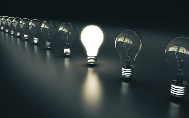 istock Light bulbs stand in a row 1185970009