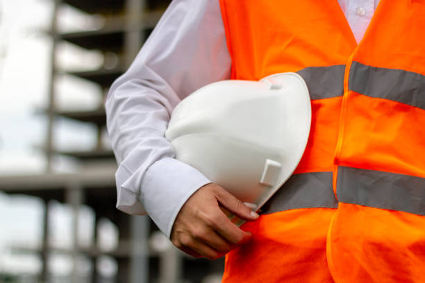 worker with white safety helmet and orange vest. construction and industrial site workers concept - reflective clothing imagens e fotografias de stock