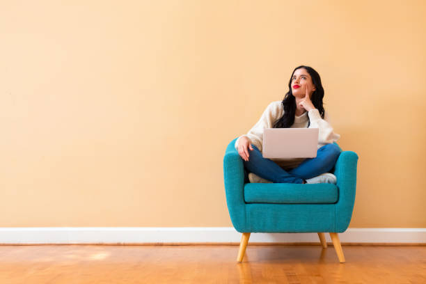istock Young woman with a laptop computer in a thoughtful pose 1185978718